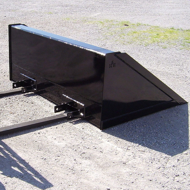 Arrow fork mounted bucket resting on gravel with a set of fork tines slid into its pockets, showing how the bucket seats over existing forks
