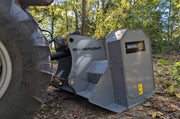 Grey MP348 mounted behind a tractor in autumn leaf litter, the BAUMALIGHT MP348 nameplate on the near end plate and a tractor tyre at the left