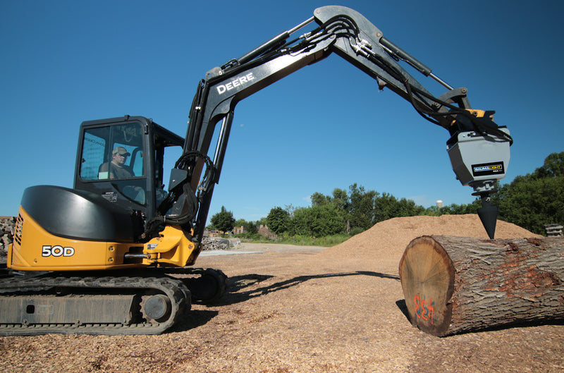 Deere 50D excavator holding the RSX380 above a log in a chip yard