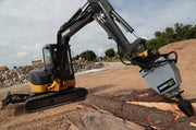 Deere 50D driving the RSX380 into split timber beside a chip pile