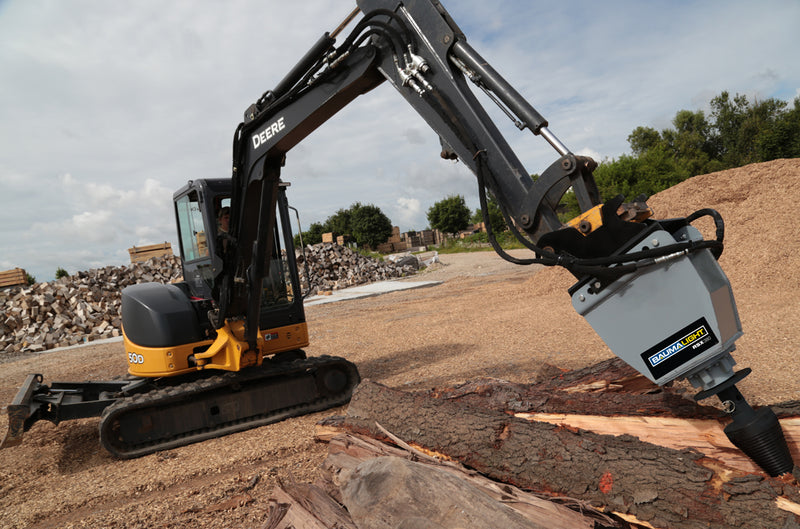 Deere 50D driving the RSX380 into split timber beside a chip pile