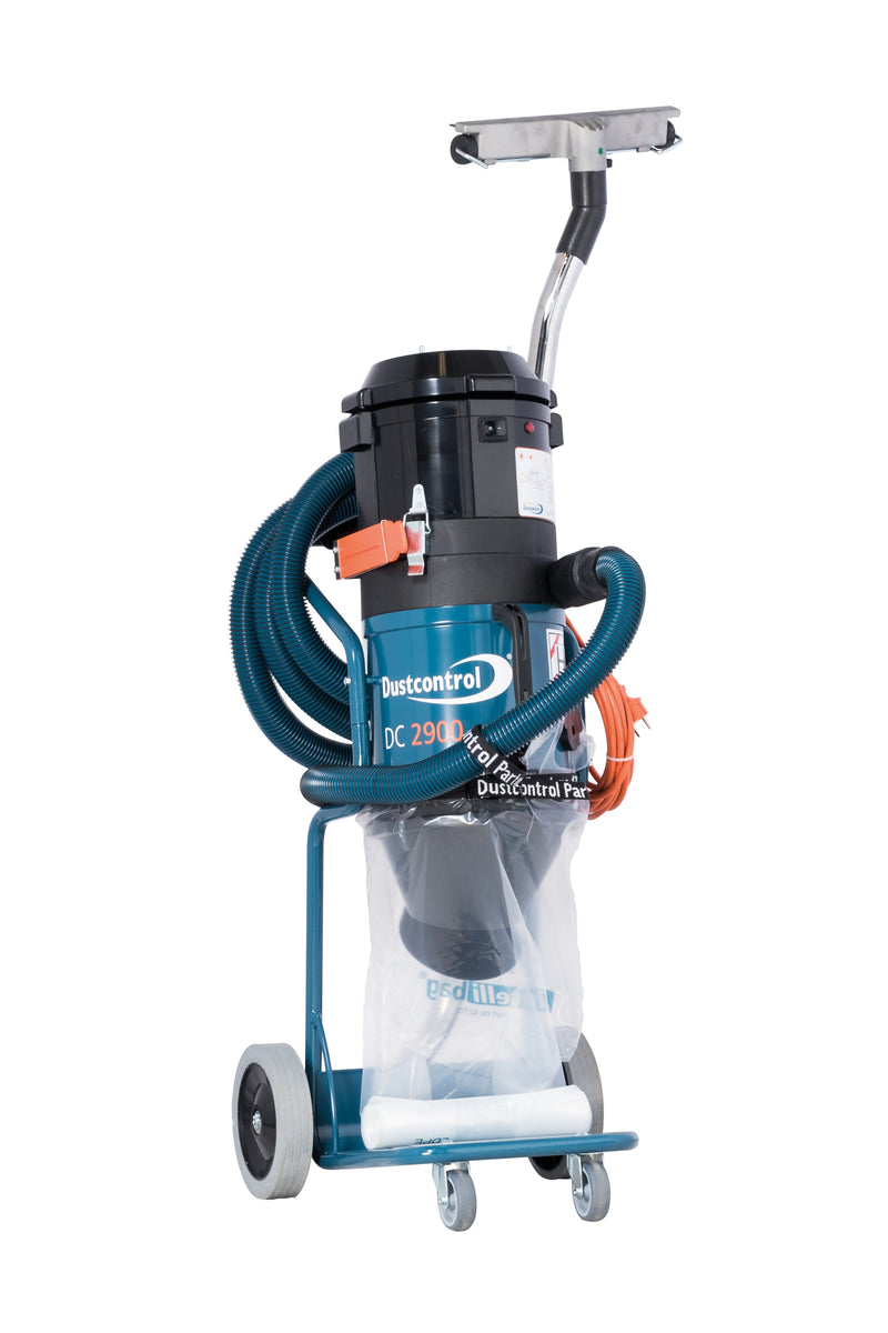 Dustcontrol DC 2900 c dust extractor on a teal two-wheel trolley, black cyclone head, clear plastic collection bag below and coiled suction hose