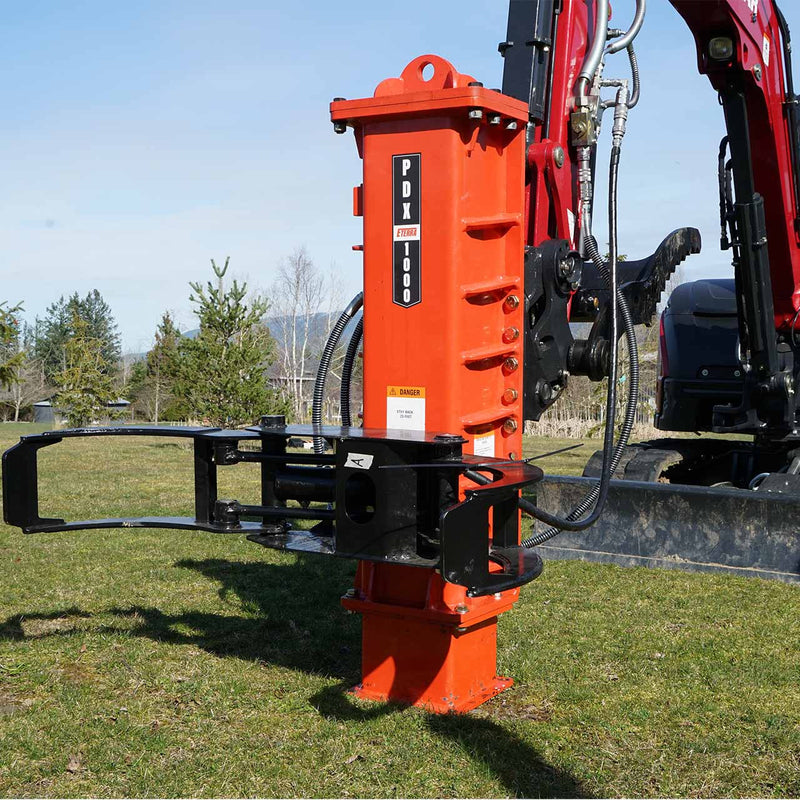 Eterra PDX-1000 excavator post driver with grapple arms, mounted on a red excavator in a grass field