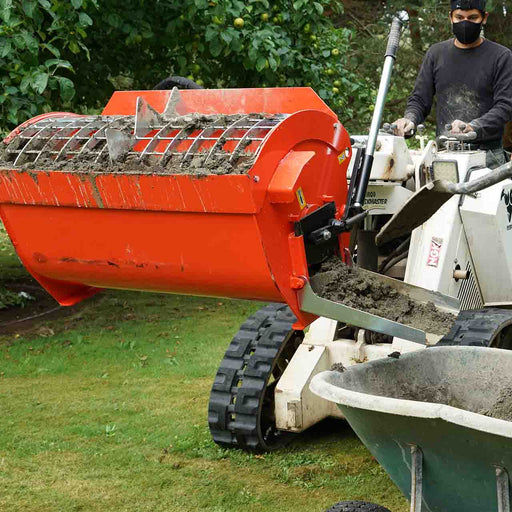 Hurricane mini mixer loaded with wet mortar on a white Ramrod Taskmaster mini skid steer, discharging down the chute beside a wheelbarrow in an orchard