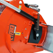 Close-up of the Hurricane mini mixer discharge end showing the spring-assisted side gate linkage, its actuating cylinder and the galvanised chute, against a white background