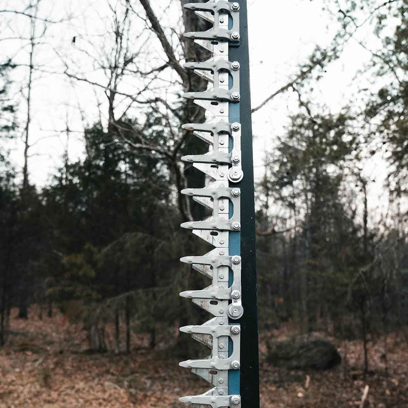 Close-up of the sickle bar showing the serrated triangular cutter sections bolted along the dark bar with their guards