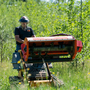 Sidewinder flail mower raised and tilted to show the underside, with the flail rotor, the Y-knife blades and the full-width rear roller exposed