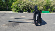 Glacier hydraulic pallet forks standing upright on a paved lot, front view of the frame and blades