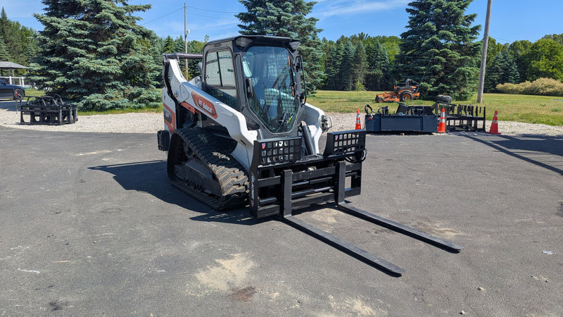 Glacier hydraulic pallet forks, mounted on a compact track loader with the blades extended forward