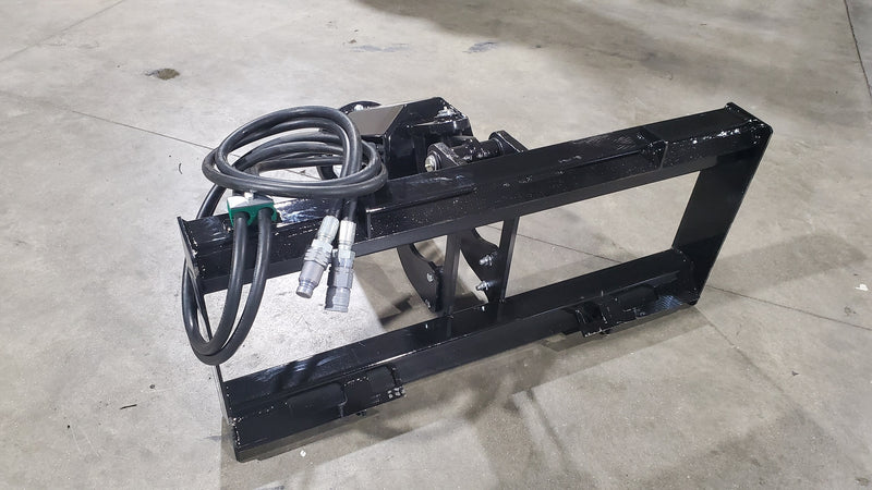 Glacier auger drive head and mount frame on a shop floor, with the hydraulic hoses and couplers coiled on the frame