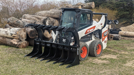 Glacier Extreme clam-shell rake and brush grapple on a skid steer beside a log pile, thick forestry tines