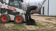 Glacier Extreme rake and brush grapple on a skid steer, side view of the curved clam-shell tines