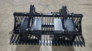 Glacier rock and brush grapple on a shop floor, head-on view across the wide tine bank with bolt-on side plates