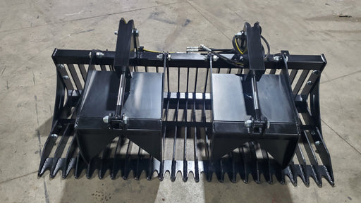 Glacier rock and brush grapple on a shop floor, head-on view across the wide tine bank with bolt-on side plates