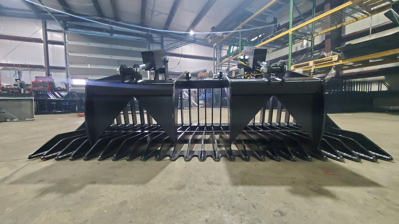 Glacier rock and brush grapple in a fabrication shop, front view of the spaced spiked tines