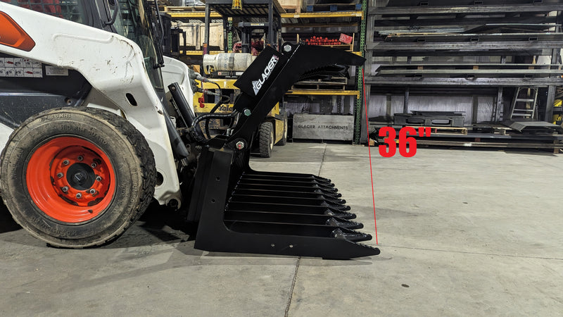 Glacier root and brush grapple on a white skid steer loader, side view with the clamp open above the tines