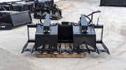 Glacier root and brush grapple resting on a pallet, angled view of the tine bank, clamp, and hydraulic cylinders