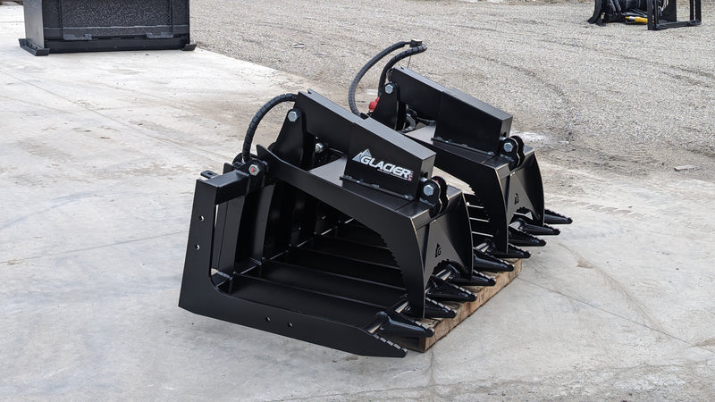 Glacier root and brush grapple on a pallet outdoors, angled view of the tine bar and the grapple arms