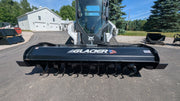 Glacier rotary tiller mounted on a Bobcat track loader outdoors, straight-on view across the tilling drum
