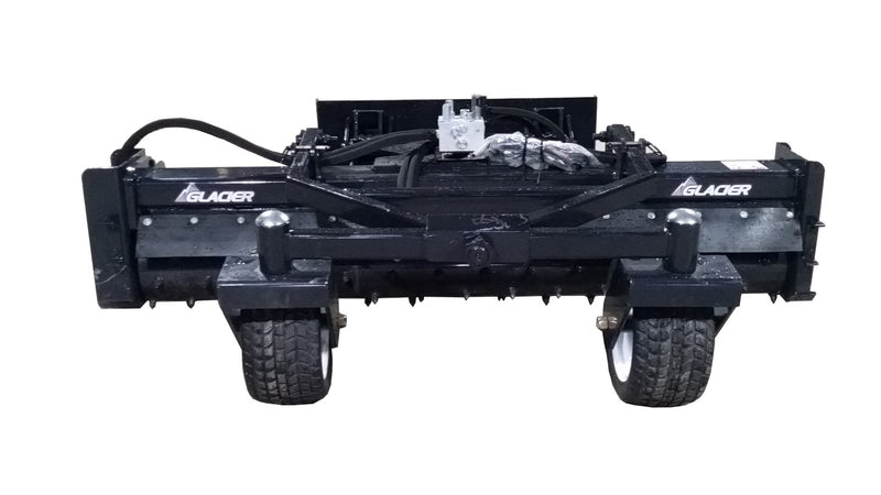 Glacier soil conditioner, studio front view showing the drum housing, end plates, flotation tires, and hydraulic manifold