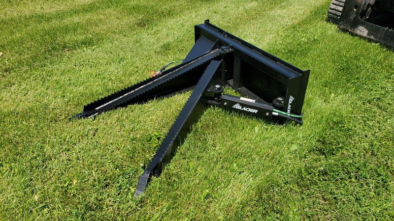 Glacier Extreme stump shark lying on grass beside a track loader, showing the two opposing serrated jaws open
