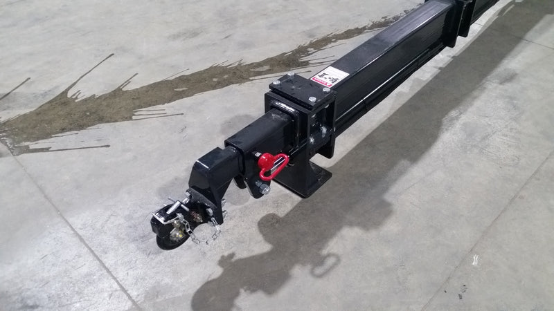 Close view of the Glacier truss boom tip on a shop floor, showing the pintle-style locking hook and safety pin