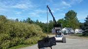 Glacier truss boom raised high on a track loader outdoors, with the lifting chain hanging from the boom tip
