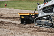 HitchDoc 6-Way Dozer Blade at work in gravel, close side view showing the moldboard, the trip spring and the blade angled to windrow material