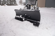 Head-on view of the HitchDoc mini skid steer angle blade set straight, showing the full face of the rolled moldboard, the bolted cutting edge along the bottom and the skid shoe at the blade end