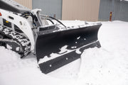 HitchDoc mini skid steer angle blade from the carrier side, showing the quick connect hydraulic couplers and hoses running from the loader arms to the blade, the mount frame and the end plate of the moldboard