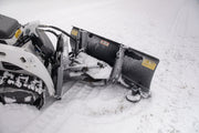 HitchDoc mini skid steer angle blade seen from behind on a Bobcat mini track loader, showing the A-frame between the two trip springs, the red and white KWIK-WAY decal and the warning decal on the moldboard back, and the skid shoe at the end
