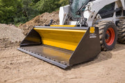 HitchDoc Push-Off Bucket empty on a white Bobcat skid steer, front three-quarter view showing the yellow extractor blade parked at the back of the bucket, the bolt heads along the full front cutting edge and the HitchDoc logo on the side shield