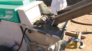 IMER Booster 20 towable diesel concrete piston pump, receiving concrete from a mixer truck