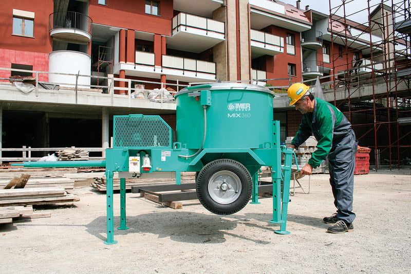 IMER Mix 360 towable vertical shaft paddle mixer, discharging mixed material into a wheelbarrow