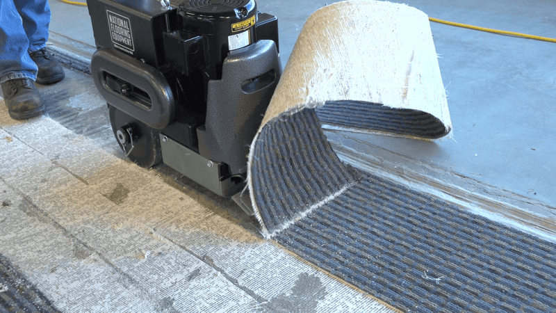 6280 Commander walk-behind scraper rolling back a strip of carpet with the flat blade plate under the backing