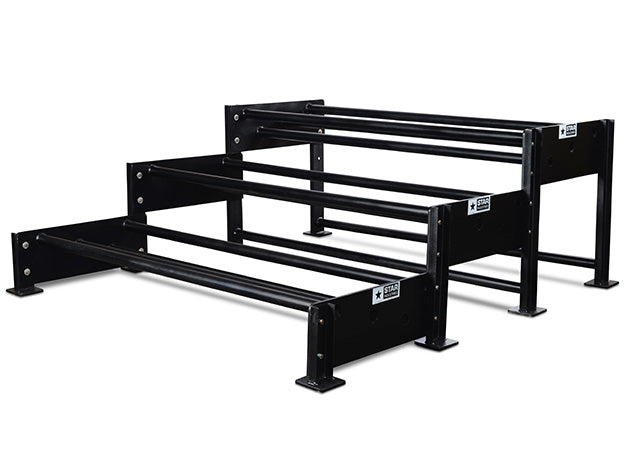 Three-level excavator bucket rack, each level a pair of tubes on stepped end frames