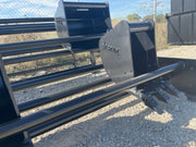 Two bucket racks in a yard with a toothed bucket standing beside them