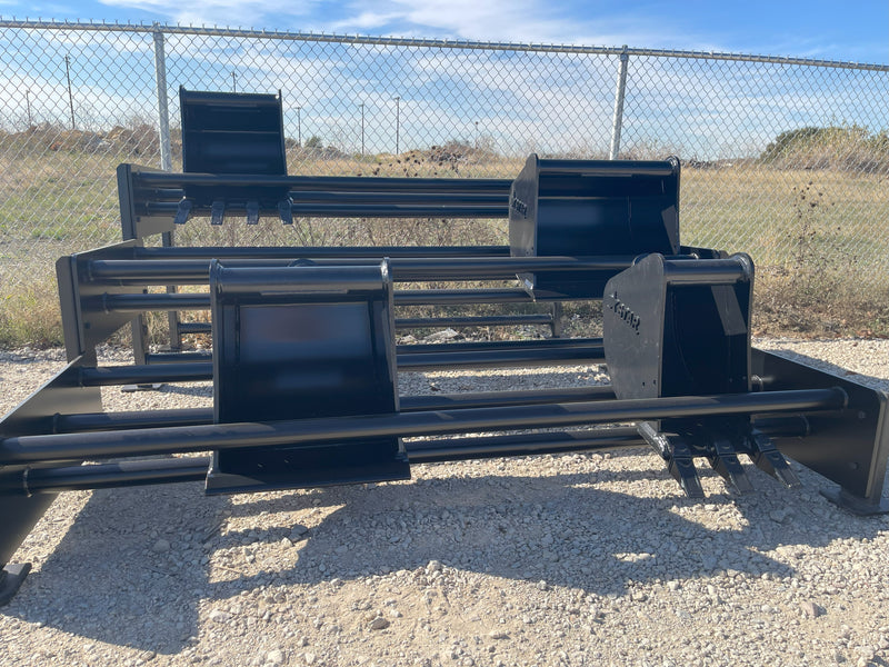 Row of bucket racks on a gravel yard, one holding a toothed bucket