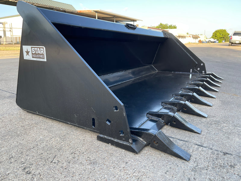 Star Industries extreme duty skid steer bucket on pavement, angled view with the pin-on tooth bank along the cutting edge