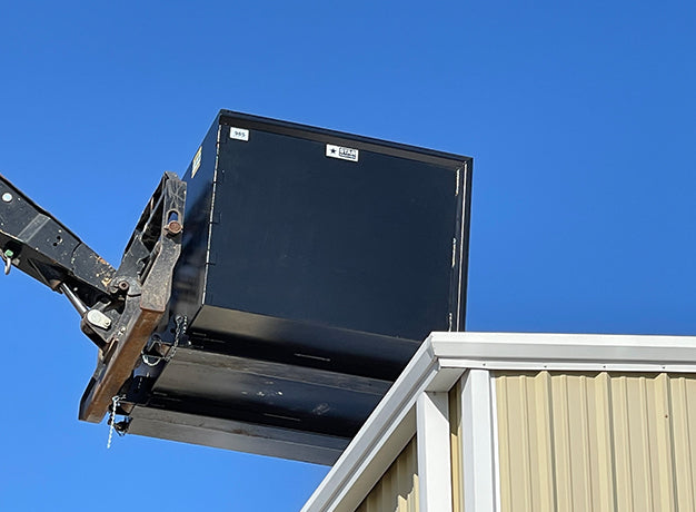 Trash hopper raised past a roof edge with the empty weight sticker visible