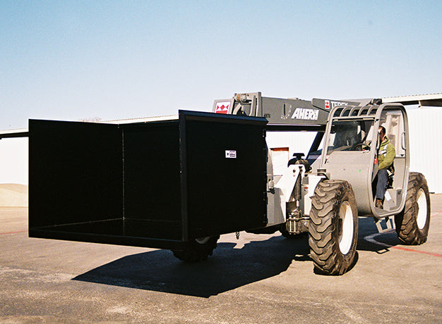 Telehandler holding the trash hopper alongside, seen from the side