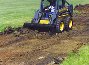 Skid steer back-dragging soil level with the heavy duty bucket's square bottom