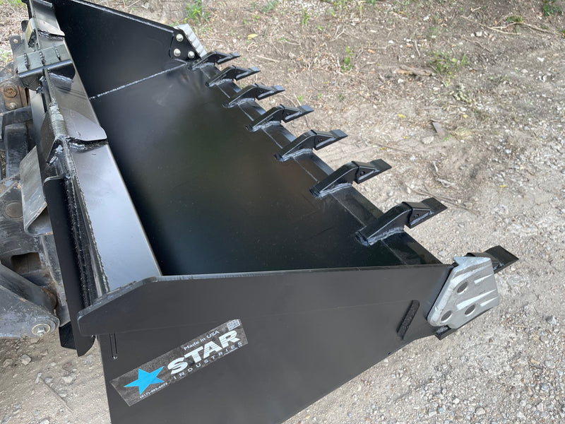 Toothed heavy duty skid steer bucket on the ground with the Star Industries badge on the side plate