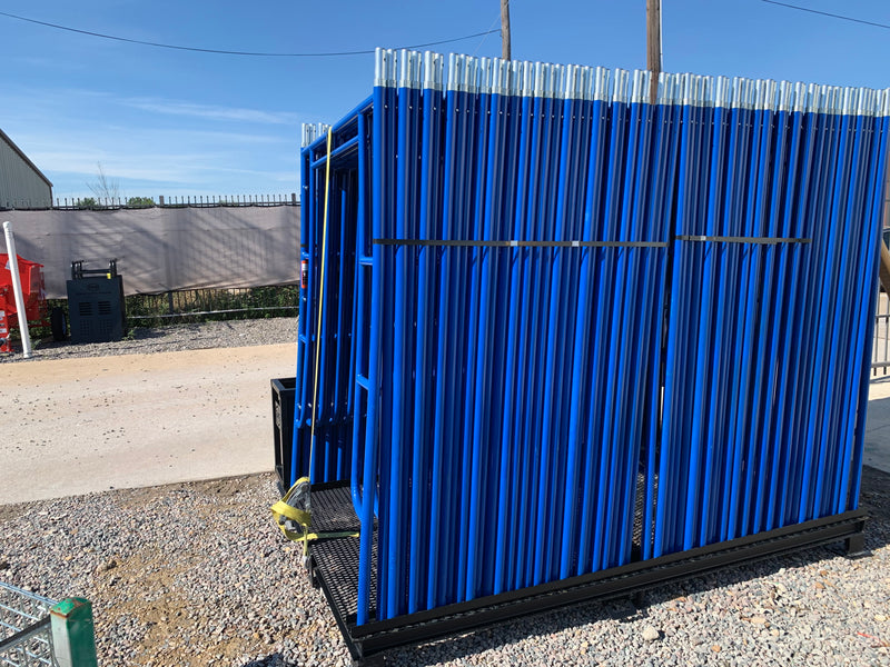Scaffold pallet loaded with blue frames standing on a gravel yard