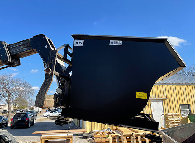 Telehandler carrying a self-dumping hopper with its empty weight sticker visible