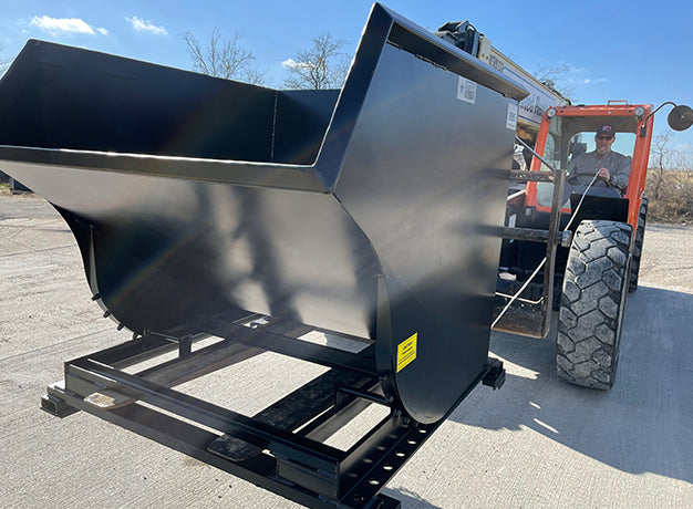 Telehandler bringing the hopper down to ground level with the operator in the cab