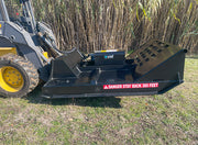 Brush cutter on a yellow skid steer parked in front of standing cane