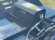 Close-up of the brush cutter motor housing with the Star decal and the hydraulic hoses running into it