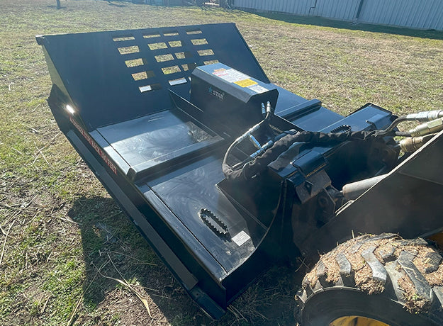 Brush cutter deck from above showing the top plate, the motor housing and the hose bundle to the loader