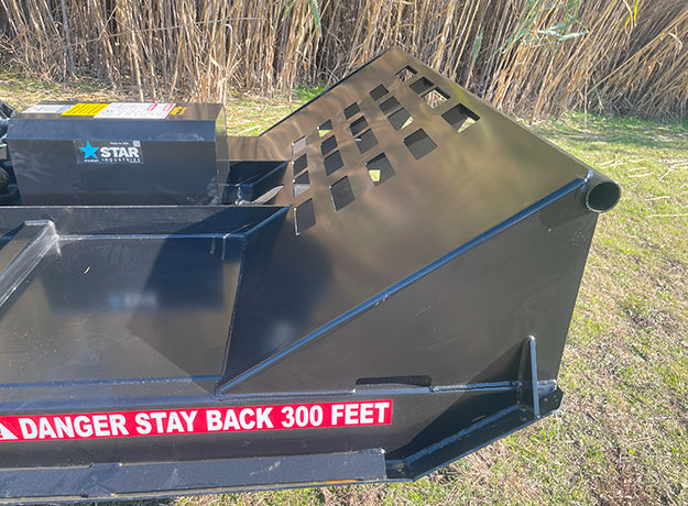 Rear quarter of the brush cutter deck showing the open back and the guard grate over the motor housing